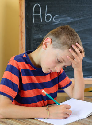 Young boy trying to do his homework.